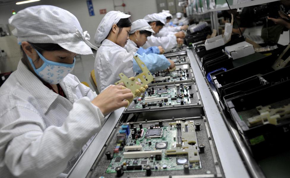 Chinese workers assemble electronic components at Foxconn's factory in Shenzhen