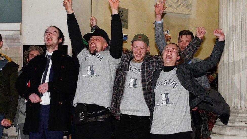 The four defendants celebrate being acquitted outside court