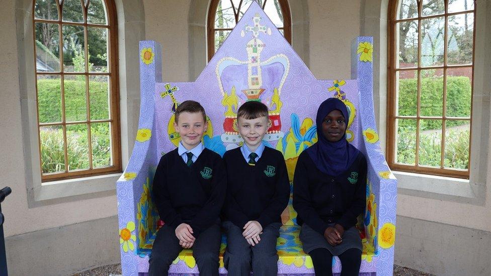 Junior Bingham, Colton McGrath and Sodgel Farshy sit on the bench they designed to mark the Coronation