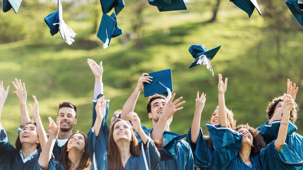 People throwing their graduation caps