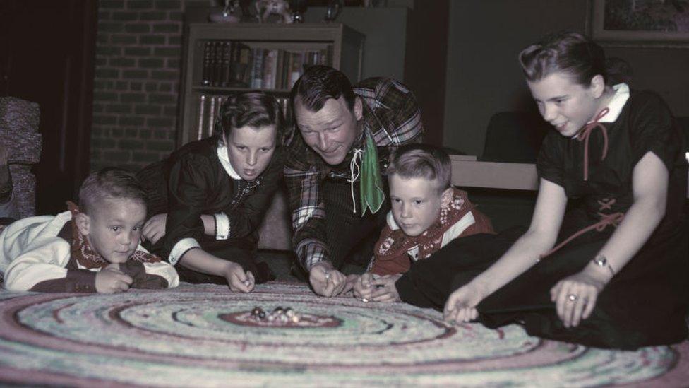 American actor and singer Roy Rogers (1911 - 1998) playing marbles with his children in the family living room, circa 1955. From left to right, Sandy, Marion Fleming (his foster daughter), Roy Rogers, Roy Jr. aka Dusty, and Linda Lou. (Photo by Archive Photos/Getty Images)