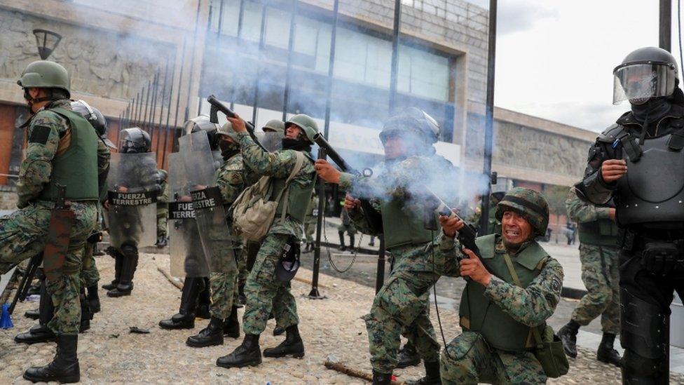 Security forces aim weapons at the entrance of the National Assembly building, in Quito, Ecuador, October 8