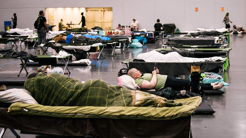 People rest at the Oregon Convention Center cooling station in Oregon, Portland