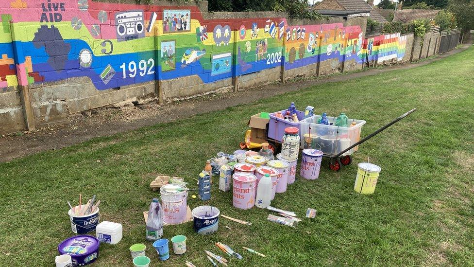 Paint pots beside mural in Hardingstone