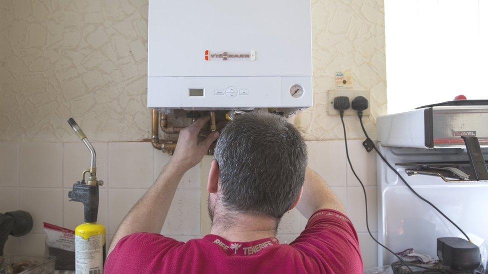 A plumber installs a new boiler