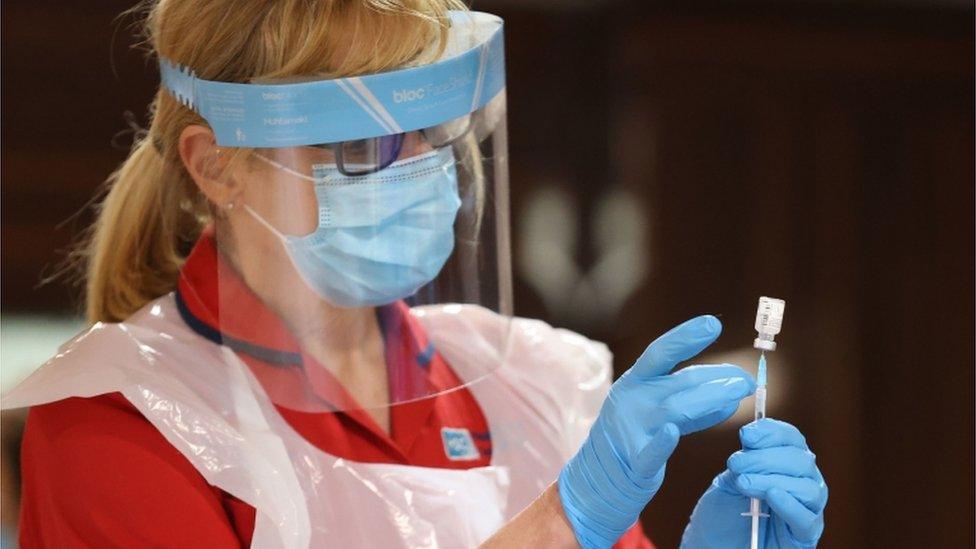 A nurse from the Belfast Trust Vaccine Team prepares to inject care home staff with the Pfizer/BioNtech covid-19 vaccine at Bradley Manor residential care home in Belfast