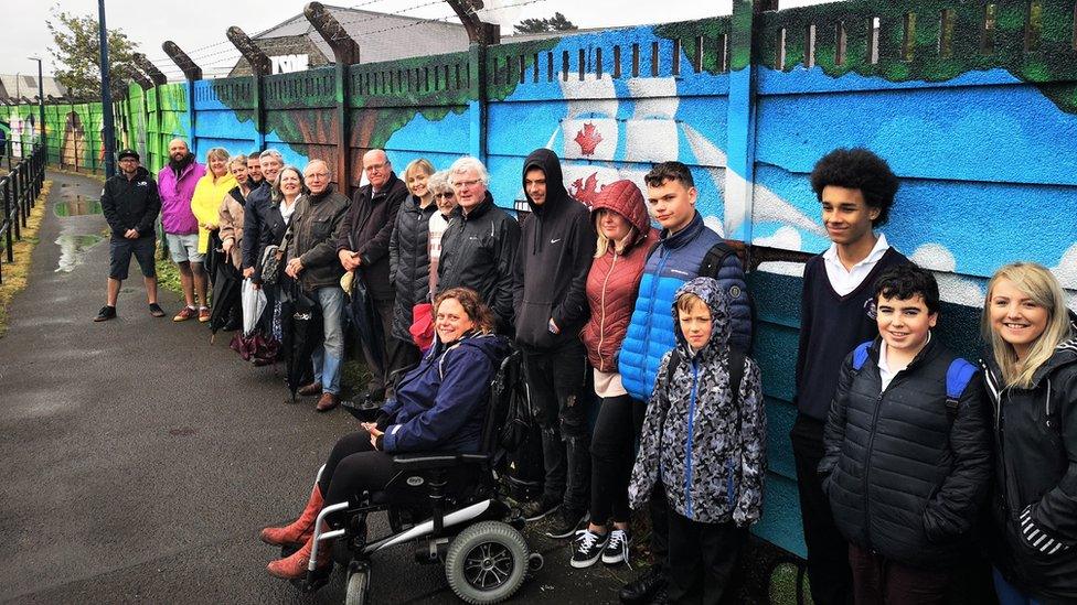 People standing in front of Teifi riverside mural