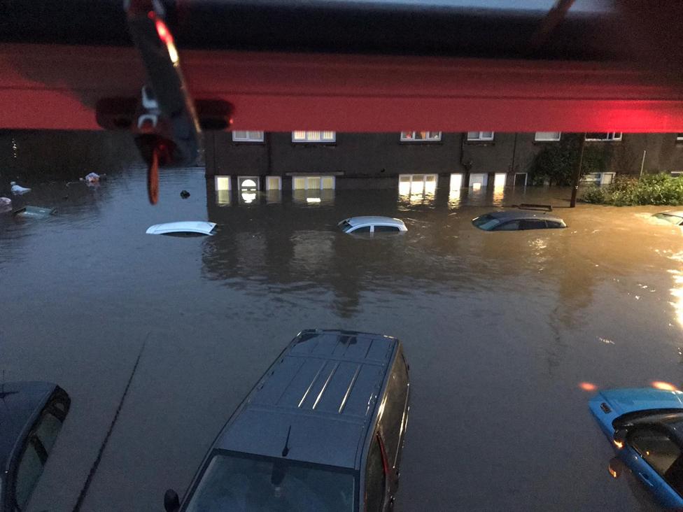 Houses and cars are semi-submerged by floodwater on Oxford Street, Nantgarw.