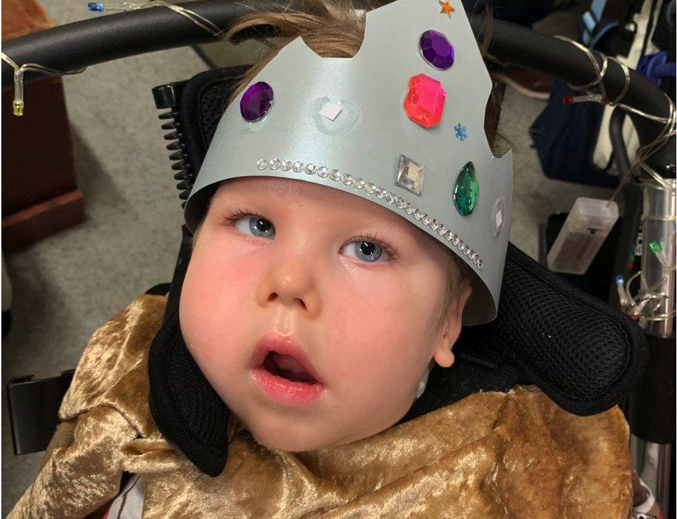 Arthur Spackman in his wheelchair wearing a crown made of silver card with gems stuck on it