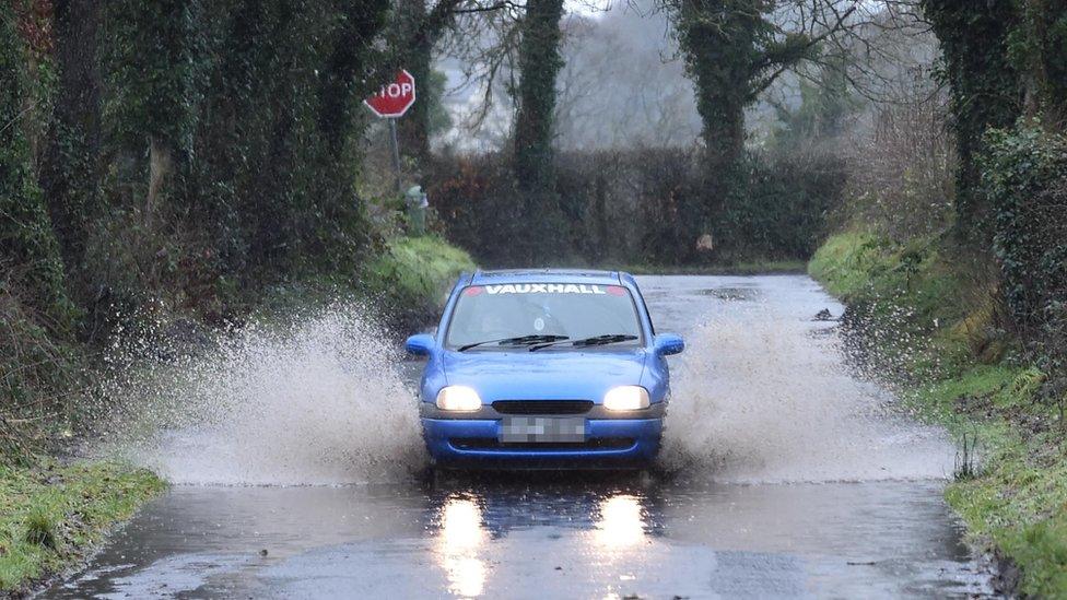 Car drives through flooded road