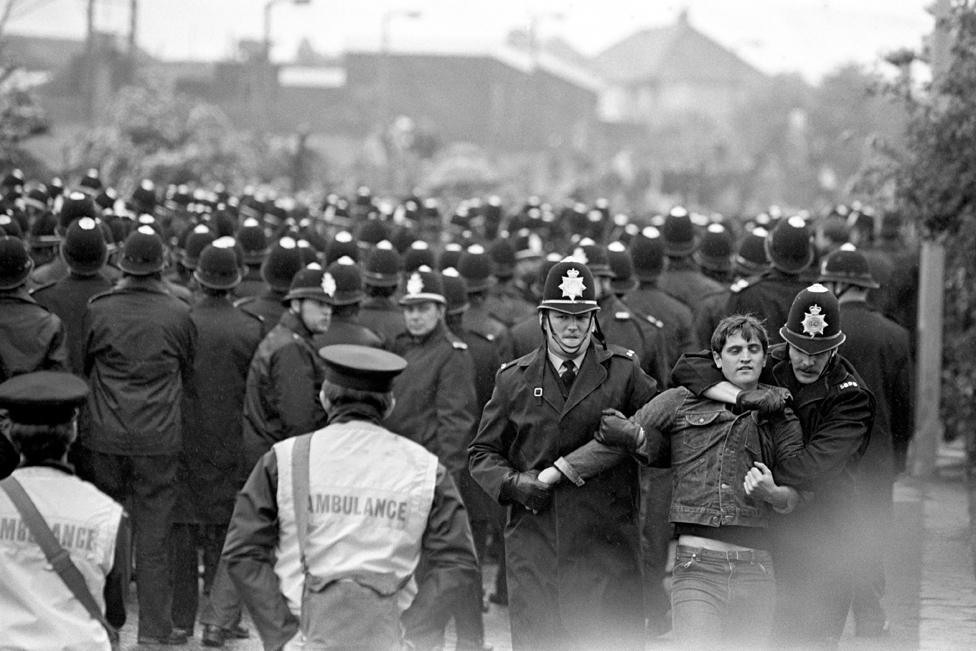 Miner is escorted away from the police line