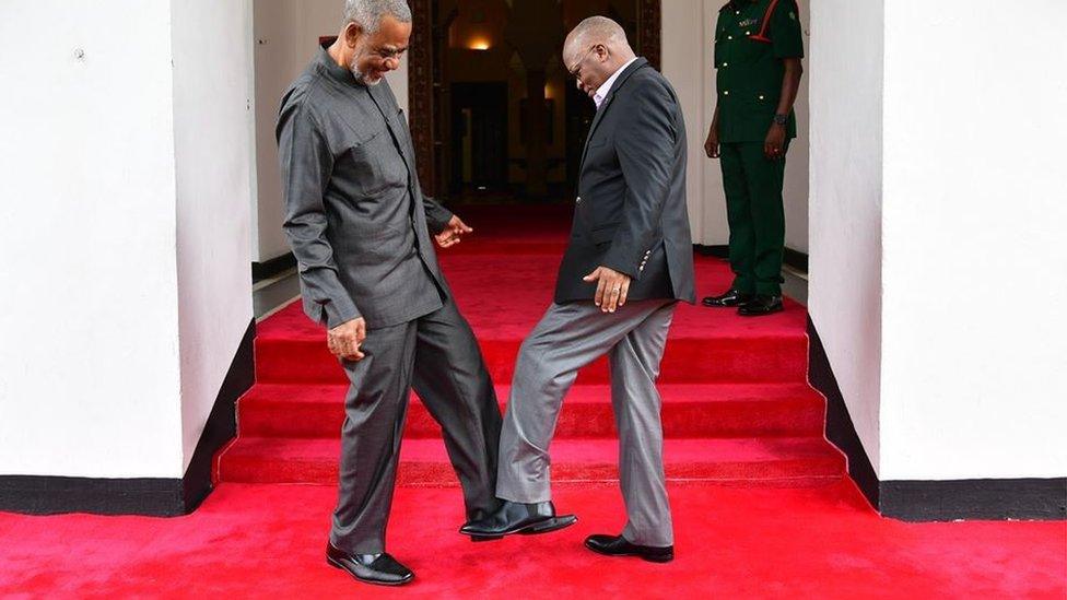 Tanzanian President John Magufuli (R) greets Tanzanian opposition politician Maalim Seif Sharif Hamad (L) by tapping his feet against theirs to avoid themselves from coronavirus in Zanzibar, Tanzania on March 03, 2020