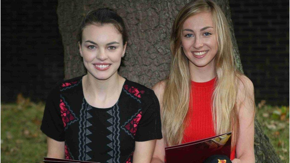 Victoria College pupils Elizabeth Brush and Jessica Sutton relaxing by a tree with their results