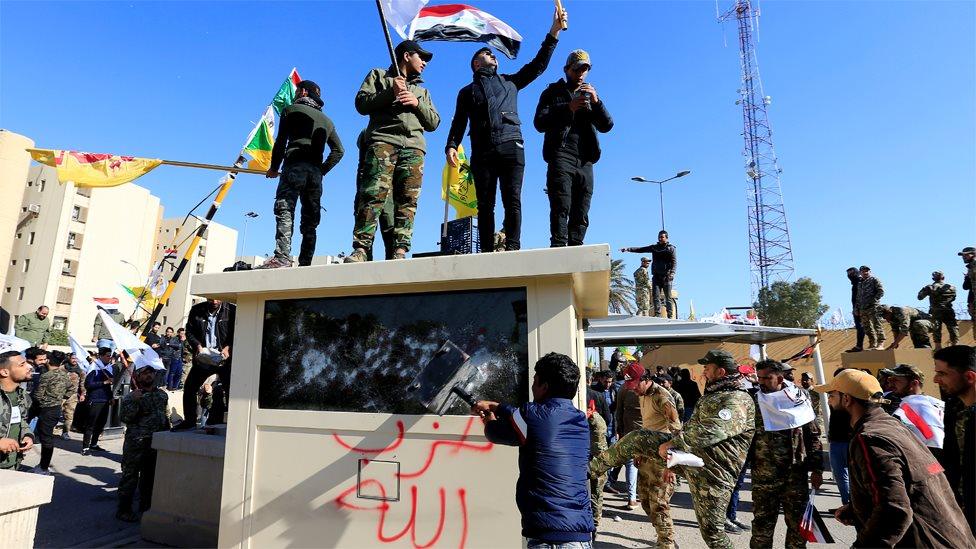 Protesters attack a security post outside the US embassy in Baghdad, Iraq (31 December 2019)