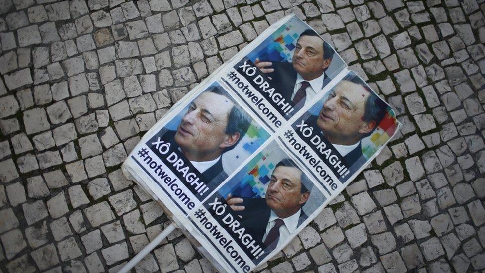 A placard is seen during a protest against the visit of European Central Bank (ECB) President Mario Draghi in Lisbon