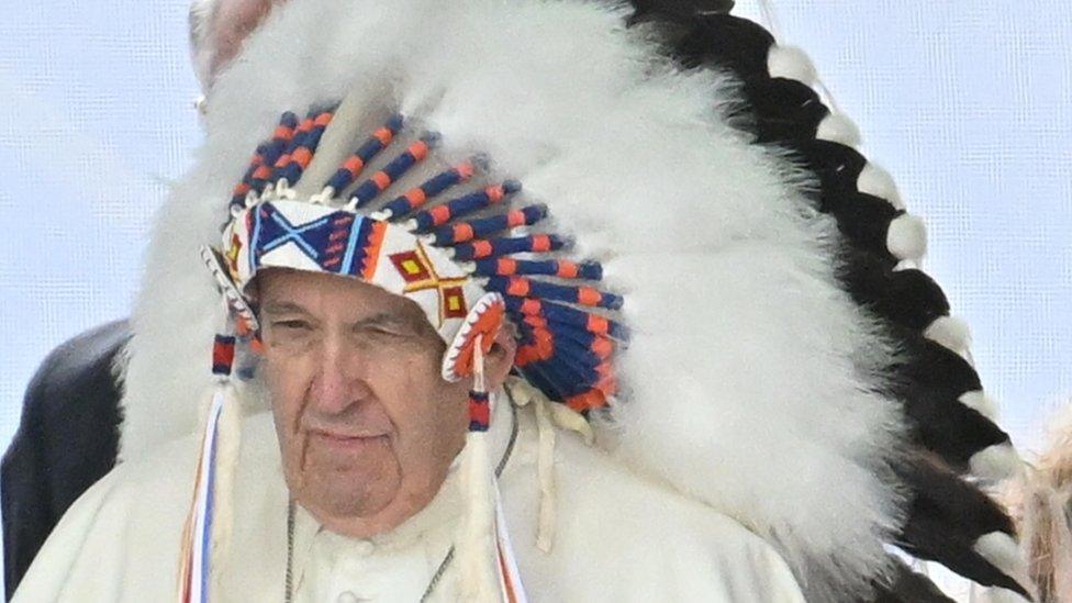 Pope Francis receives a War bonnet during a meeting with indigenous people for a silent prayer at the Maskacis cemetery, a town 100 kilometers south of Edmonton, Canada