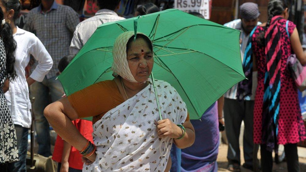 A woman walks with an umbrella