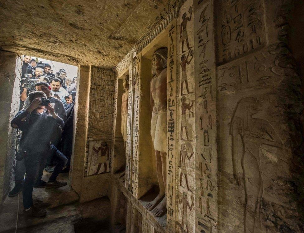 Journalists enter a newly-discovered tomb at the Saqqara necropolis, 30 kilometres south of the Egyptian capital Cairo