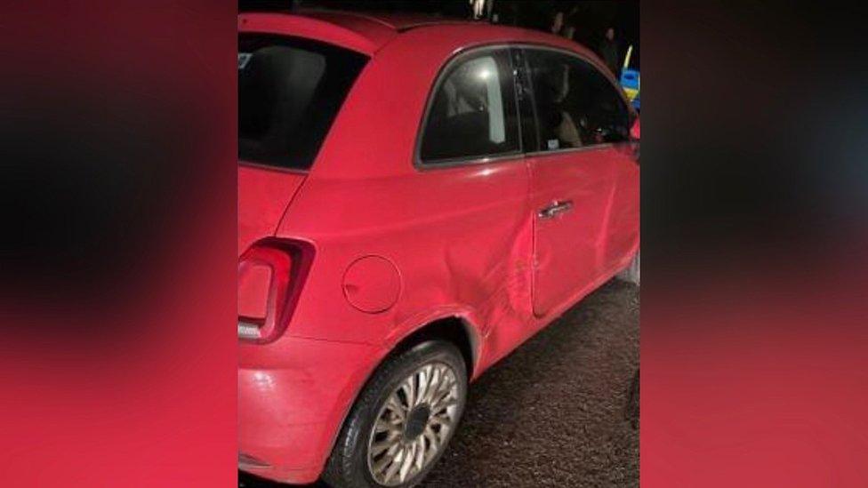 Pink car with damage to offside front door