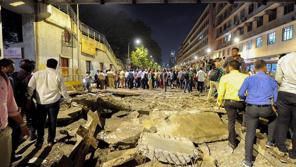 People help move debris after a bridge collapse in Mumbai