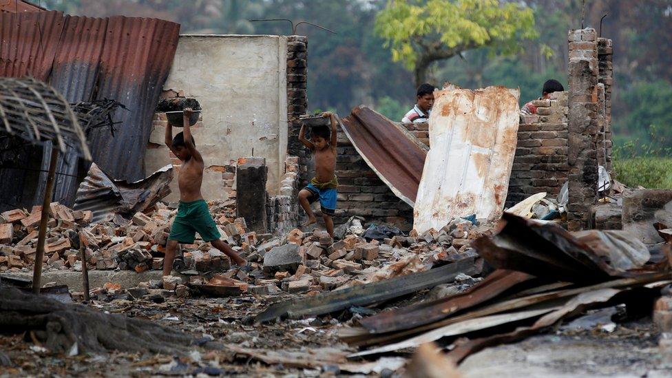 Children recycle goods from the ruins of a market which was set on fire at a Rohingya village outside Maugndaw in Rakhine state, Myanmar, 27 October 2016