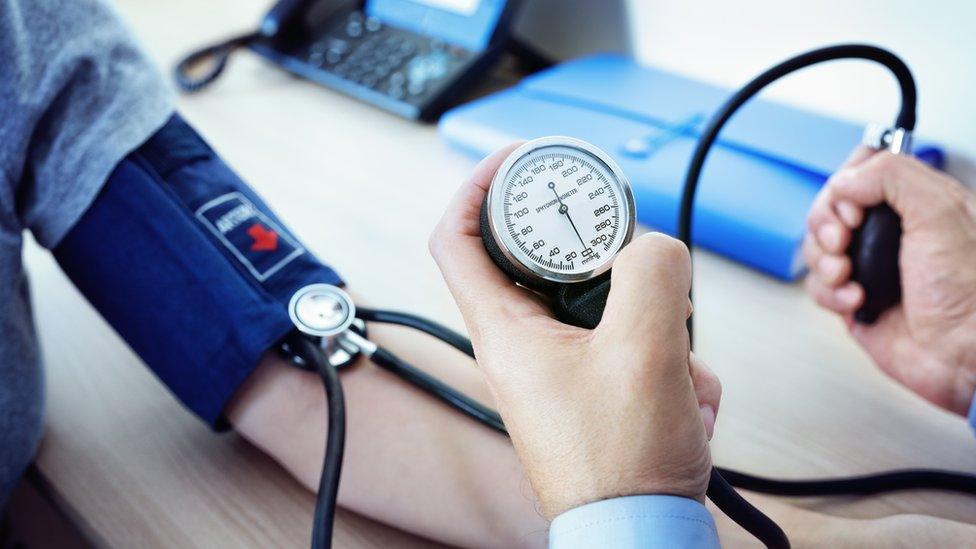 A medical professional takes blood pressure