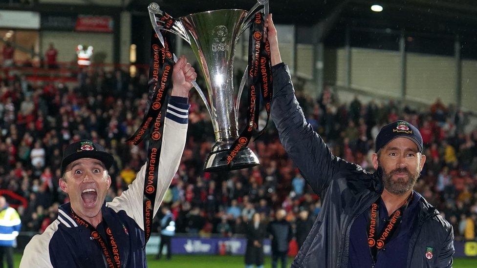 Wrexham co-owners Rob McElhenney and Ryan Reynolds celebrate with the Vanarama National League trophy