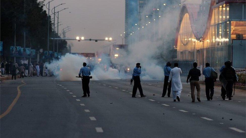 Pakistani police officers fire tear gas to supporters of executed Islamist Mumtaz Qadri who gather in Islamabad on March 27, 2016.