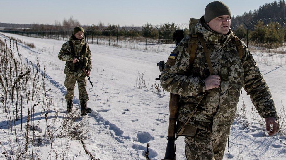 Members of the Ukrainian Border Guard patrol along the Ukrainian border fence at the Three Sisters border crossing between, Ukraine, Russia and Belarus on February 14, 2022.