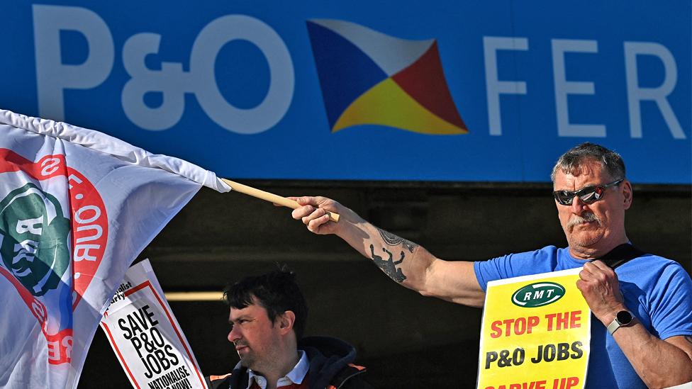 People hold banners and placards during a demonstration against the sacking of 800 P&O workers, outside their offices, Channel House, near the Port of Dover