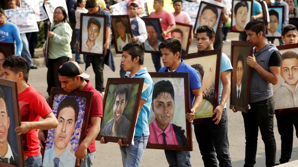 Relatives and activists holding up portraits of the 43 missing students