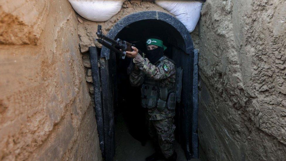 Fighter belonging to Hamas’ military wing stands in front of tunnel in central Gaza strip on 19 July 2023