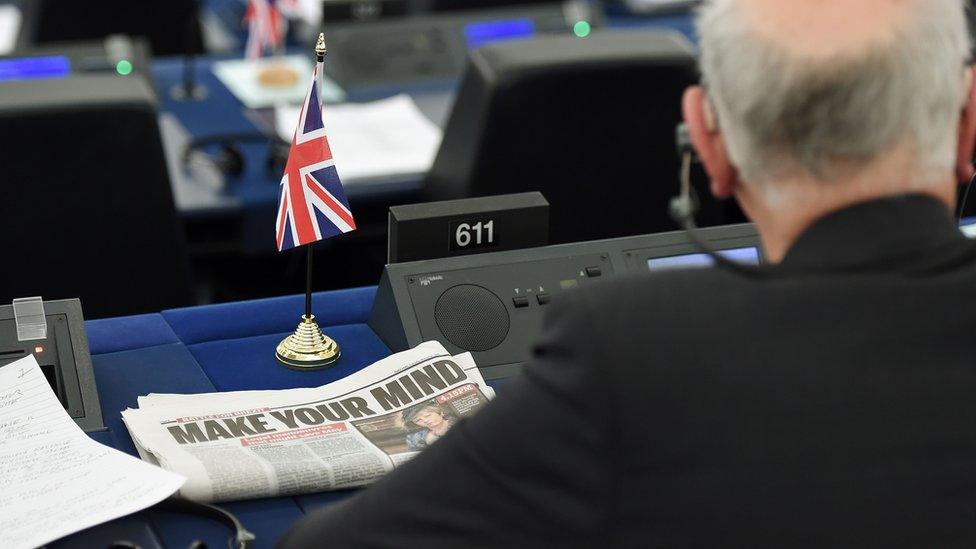 A newspaper headline shows the words "make your mind" on a British European parliament seat, complete with little UK flag