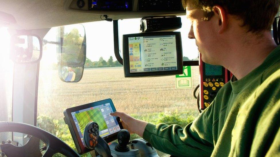 Farmer uses GPS in tractor