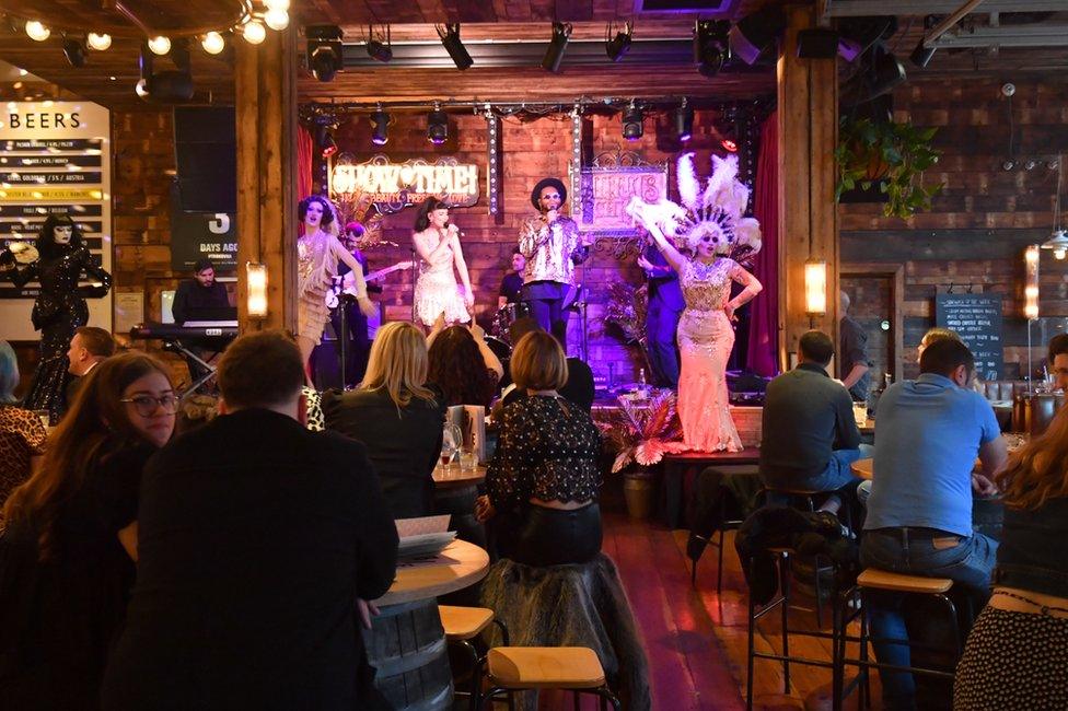 People enjoy a live show at a bar in Manchester on 17 May, following the easing of lockdown restrictions