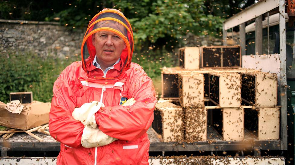 Bill Turnbull in red beekeeping suit on Horizon: What's Killing Our Bees? in 2013