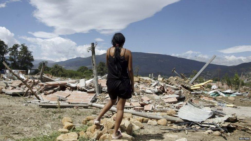 A woman stands in front of the ruins of houses demolished by Venezuelan officials in San Antonio, Venezuela, on 24 August, 2015.