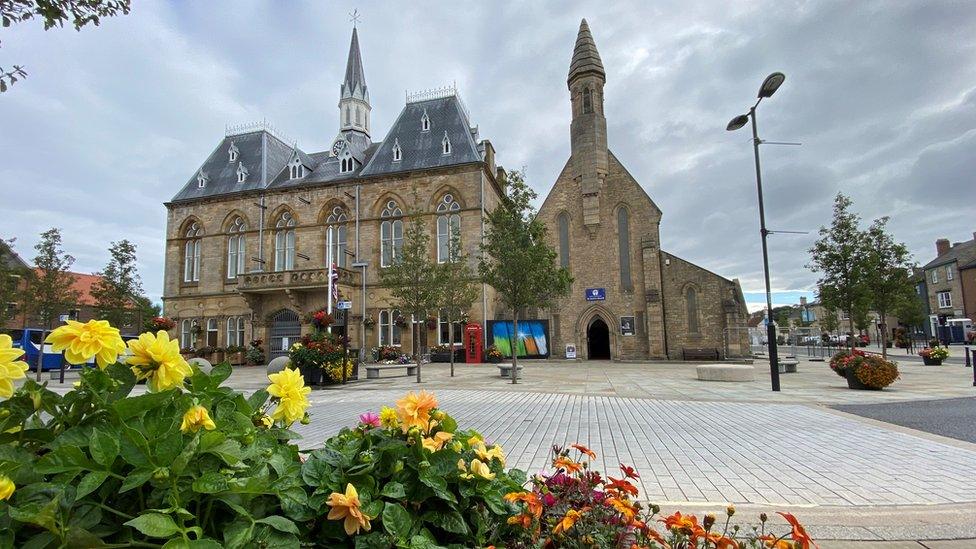 General view of the church next to the chateau-style town hall