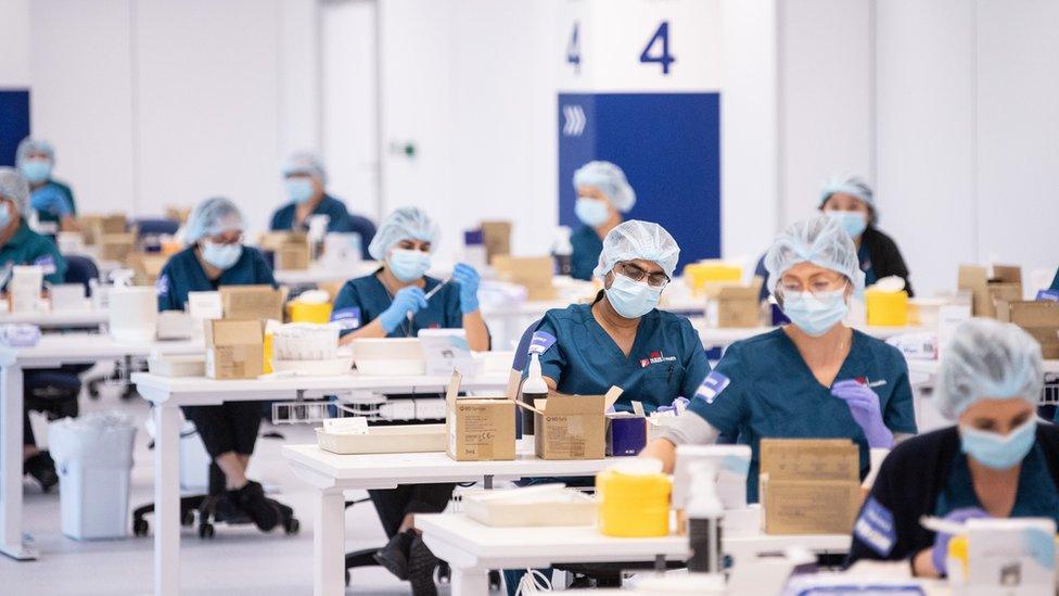 Nurses at vaccination stations at a mass vaccination site in Sydney