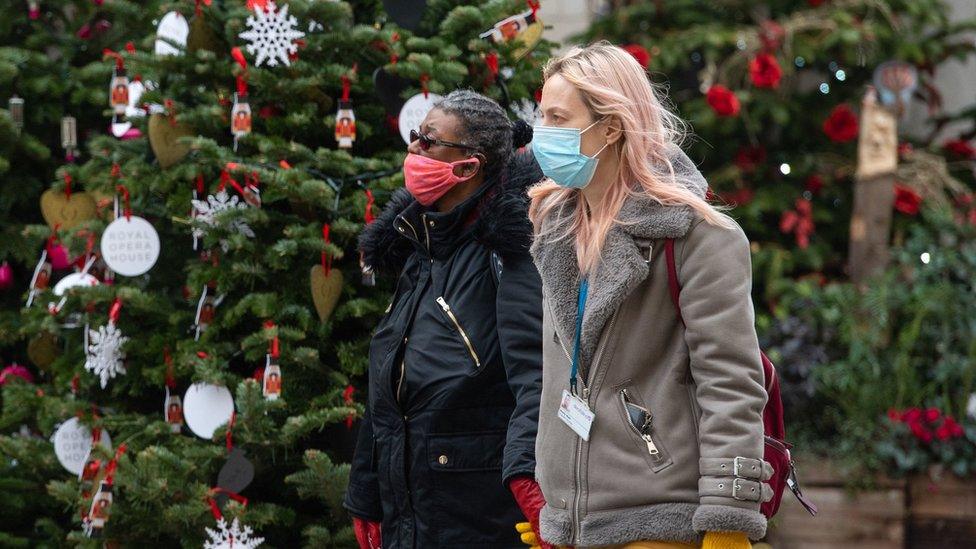 People walking next to Christmas tree