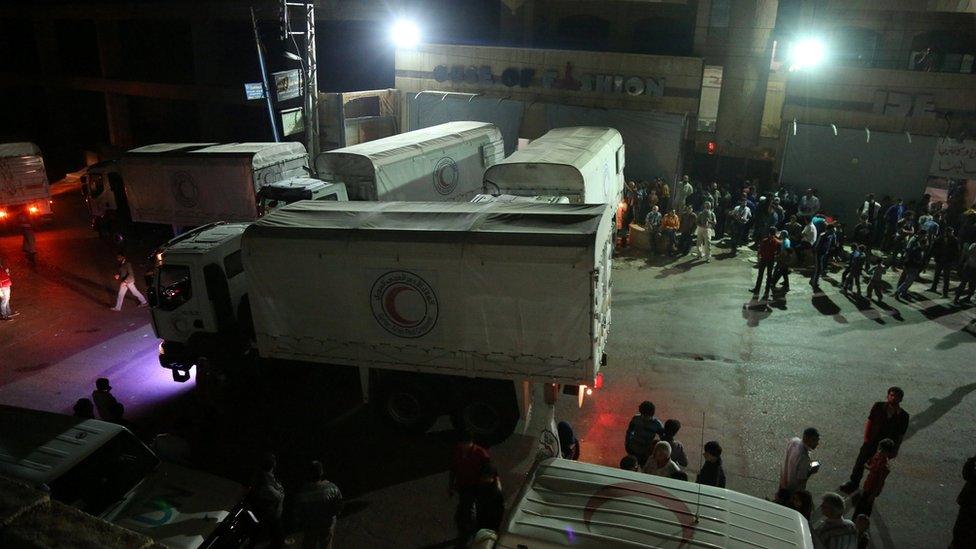 Workers unload food and humanitarian supplies at the Syrian besieged town of Madaya, near Damascus in this handout picture taken on 25 September