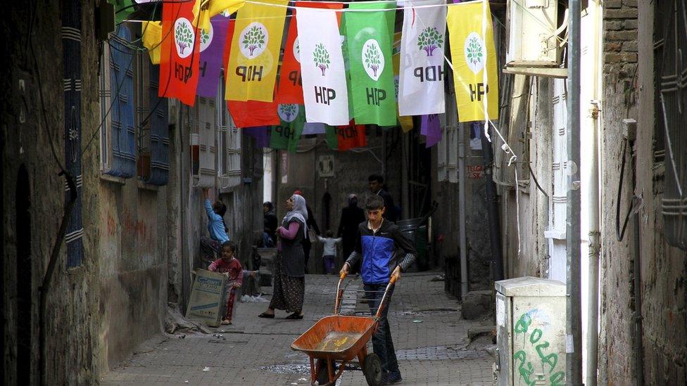 A boy pushes a cart on a street past election banners of the pro-Kurdish party in Diyarbakir - Saturday 31 October 2015