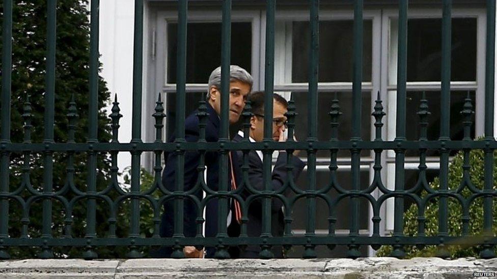 US Secretary of State John Kerry (left) walks using crutches at the garden of Palais Coburg, the Vienna hotel where the Iran nuclear talks meetings are being held (09 July 2015)