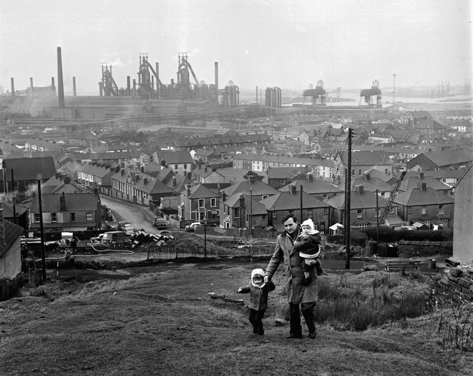 Out of work steel worker Peter Dixon with his children, walking through the industrial landscape of Port Talbot, Wales, 15th January 1964