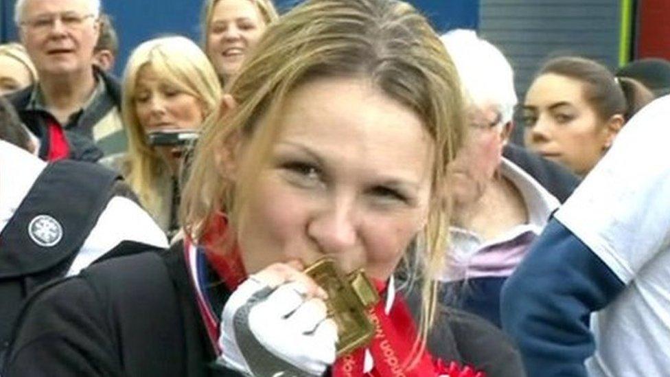 Claire Lomas kisses her medal for completing the London Marathon