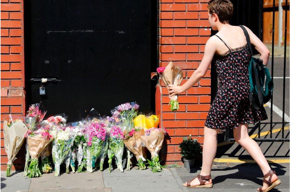 A woman lays flowers in tribute outside Finsbury Park Mosque in the Finsbury Park area of north London