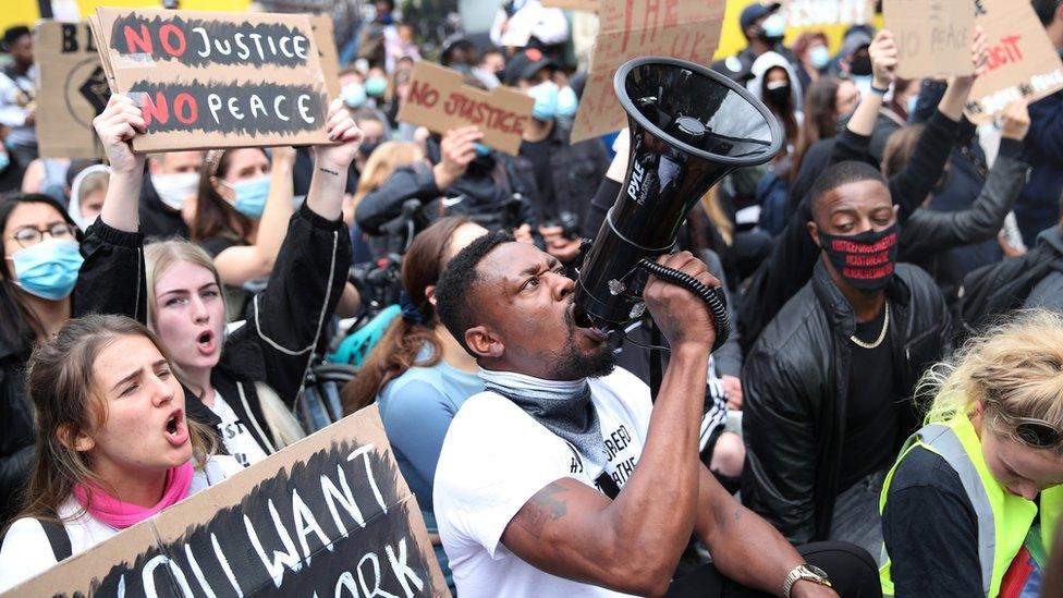 A demonstrator shouts through a megaphone outside London's US embassy