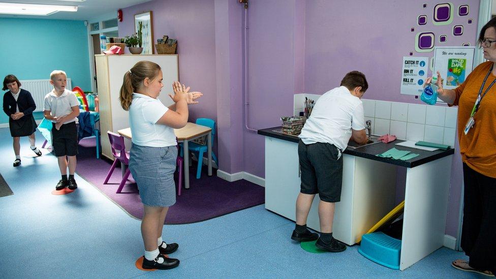 Pupils queue to wash their hands