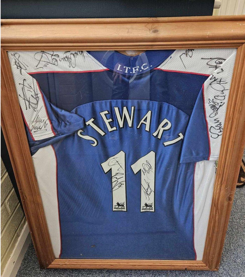 Framed blue Ipswich Town kit with a number 11 on it