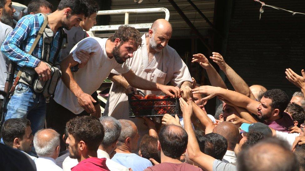 Syrians try to buy food in Aleppo